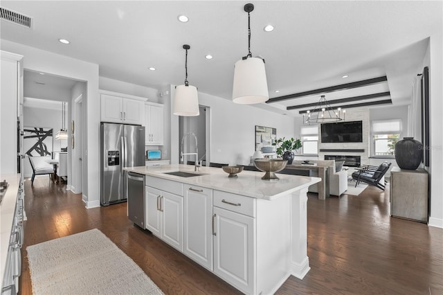 8025 Topsail Pl, Winter Garden, FL 34787 - kitchen featuring appliances with stainless steel finishes, recessed lighting, white cabinets, a sink, and a large fireplace