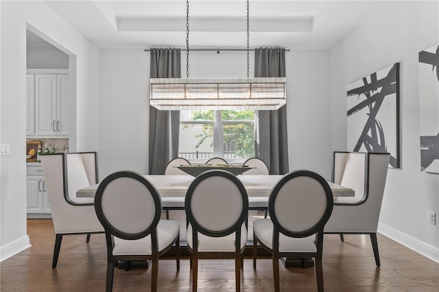 8025 Topsail Pl, Winter Garden, FL 34787 - dining room featuring a raised ceiling, dark wood-type flooring, and baseboards