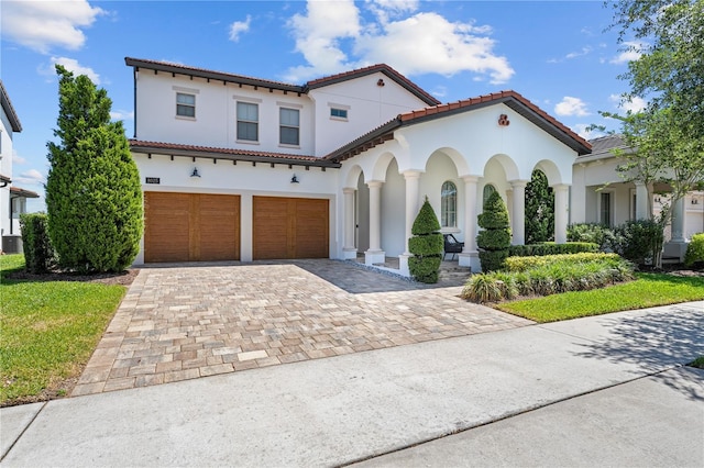 8025 Topsail Pl, Winter Garden, FL 34787 - mediterranean / spanish home with a garage, stucco siding, decorative driveway, a tiled roof, and central AC