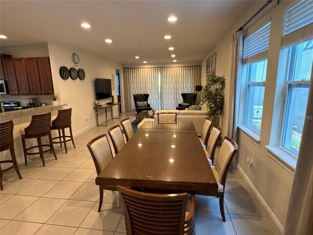 dining area featuring baseboards, light tile patterned flooring, a wealth of natural light, and recessed lighting