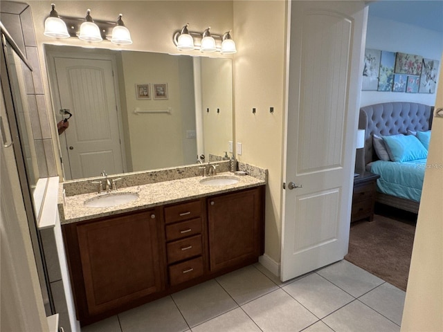 ensuite bathroom with tile patterned flooring, connected bathroom, a sink, and double vanity