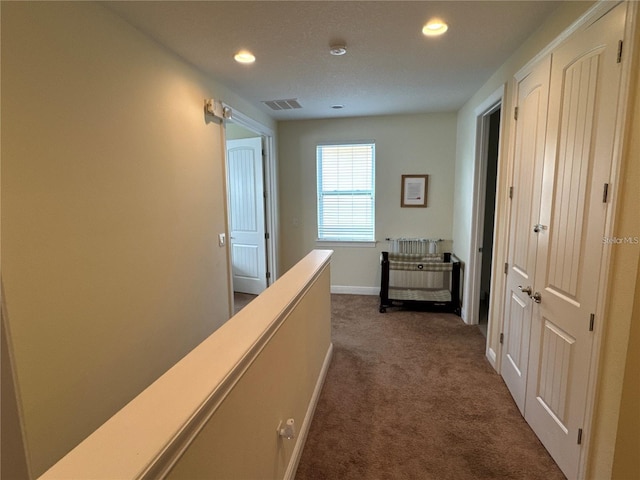 hall featuring recessed lighting, visible vents, an upstairs landing, baseboards, and dark carpet