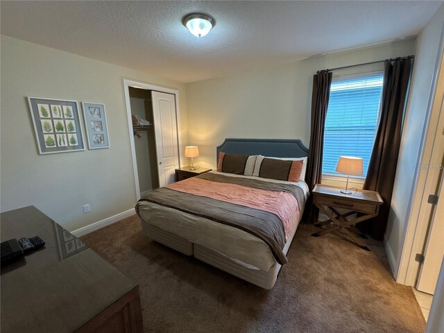 bedroom with carpet, a closet, a textured ceiling, and baseboards
