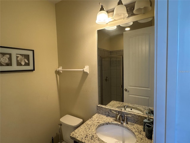bathroom with a stall shower, vanity, and toilet