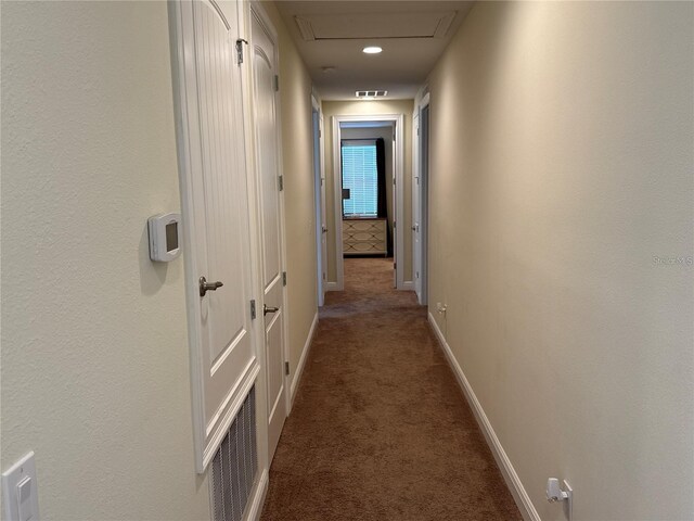 hall with carpet floors, visible vents, and baseboards