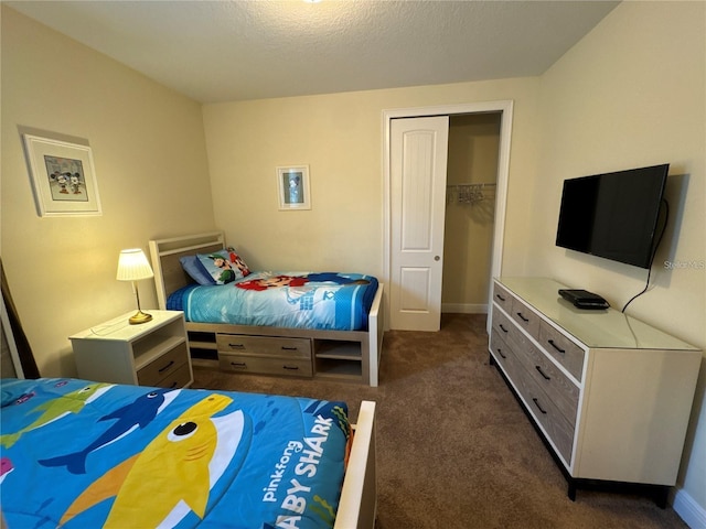 carpeted bedroom featuring a textured ceiling, a closet, and baseboards