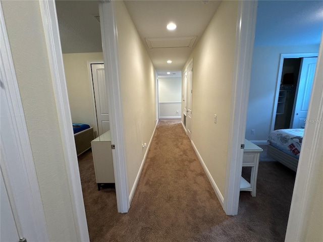 corridor with carpet, attic access, and baseboards