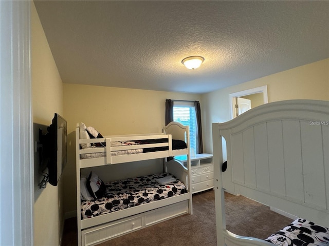 bedroom featuring a textured ceiling and carpet flooring