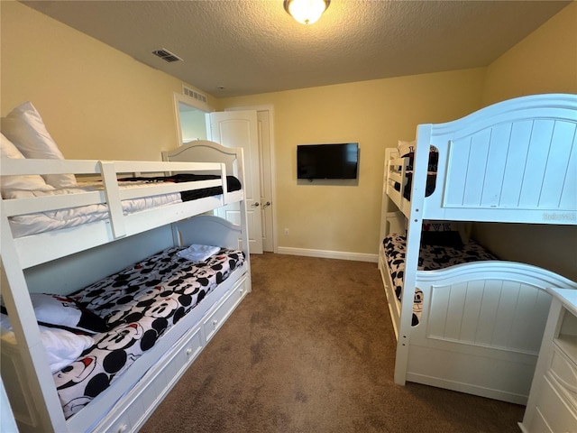 bedroom featuring baseboards, a textured ceiling, visible vents, and carpet flooring
