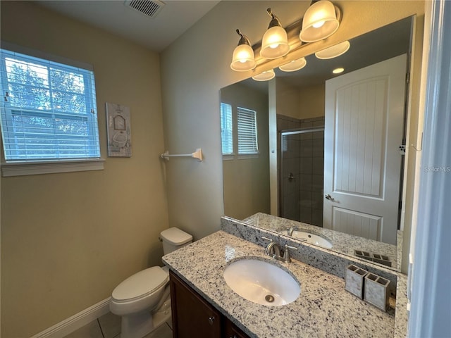 full bathroom featuring toilet, vanity, visible vents, baseboards, and a shower stall