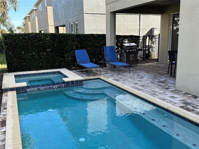 view of pool featuring a patio area, a grill, a pool with connected hot tub, and fence