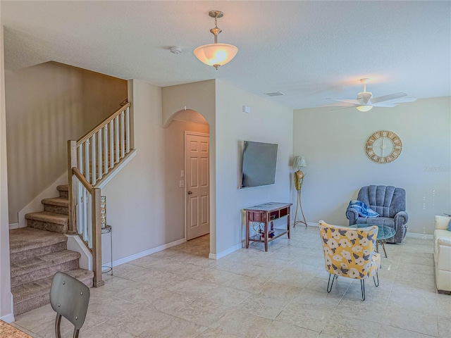 3593 Brighton Park Cir, Belle Isle, FL 32812 - interior space featuring baseboards, arched walkways, ceiling fan, stairway, and a textured ceiling