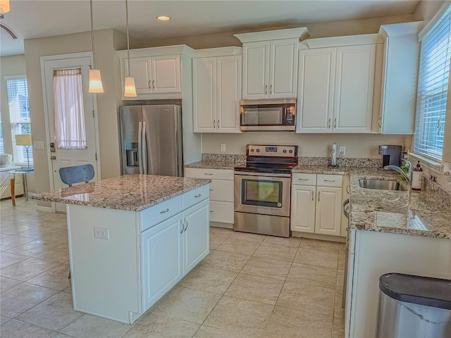 3593 Brighton Park Cir, Belle Isle, FL 32812 - kitchen with appliances with stainless steel finishes, a sink, white cabinetry, and a center island