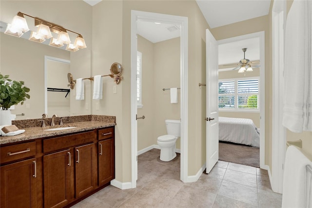 bathroom featuring tile patterned flooring, baseboards, toilet, ensuite bath, and vanity