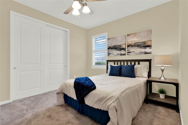 carpeted bedroom featuring a ceiling fan, a closet, and baseboards