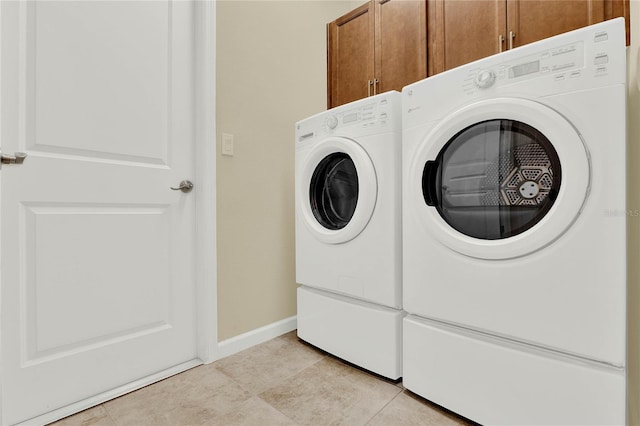 laundry room with light tile patterned floors, cabinet space, independent washer and dryer, and baseboards