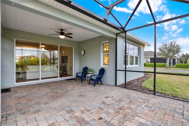 unfurnished sunroom with beamed ceiling, a healthy amount of sunlight, visible vents, and ceiling fan