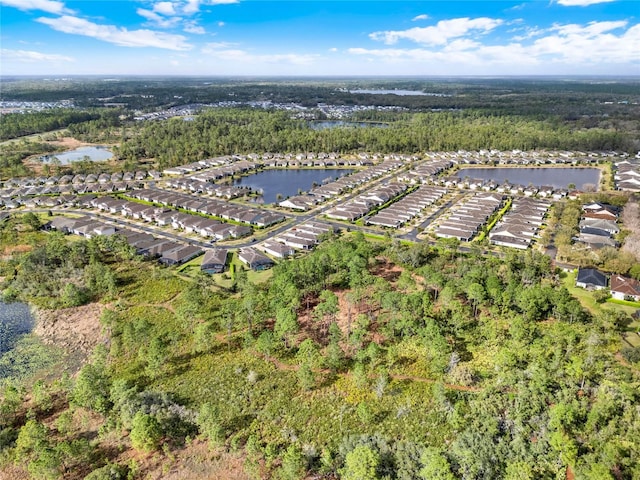 birds eye view of property with a view of trees and a water view