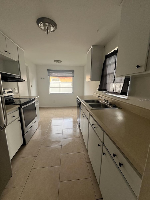 kitchen with stainless steel electric range oven, light tile patterned floors, dishwashing machine, white cabinetry, and a sink