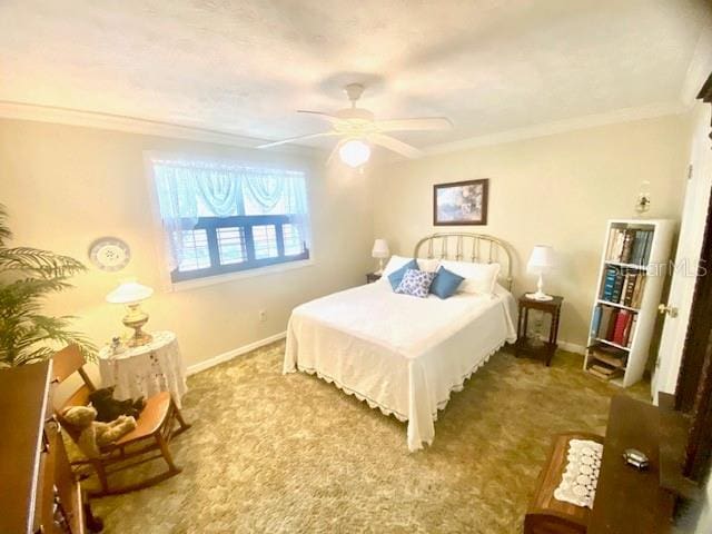 carpeted bedroom with a ceiling fan, baseboards, and ornamental molding