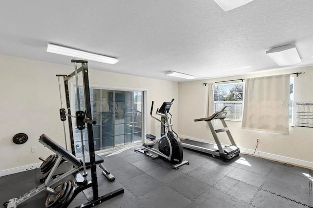 workout room featuring baseboards and a textured ceiling