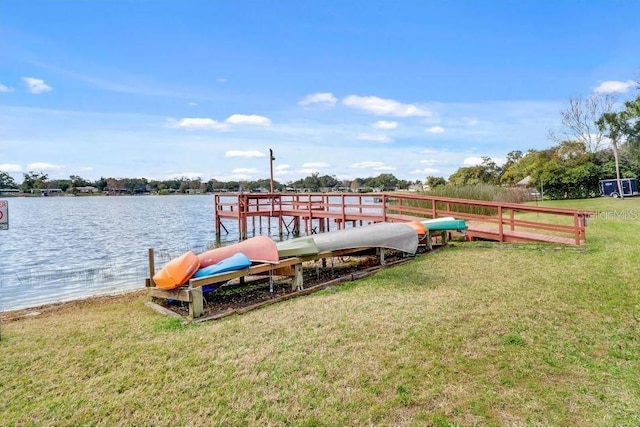 dock area with a yard and a water view