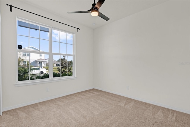 empty room with ceiling fan, baseboards, and carpet flooring