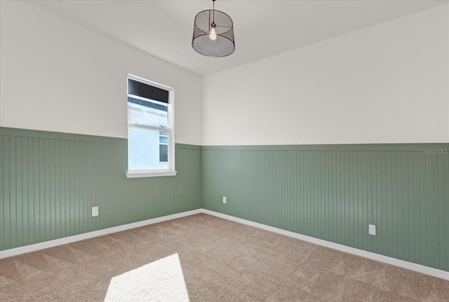 empty room with wainscoting and carpet