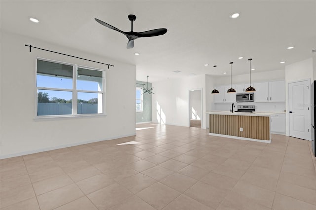 unfurnished living room featuring recessed lighting, light tile patterned floors, baseboards, and ceiling fan with notable chandelier