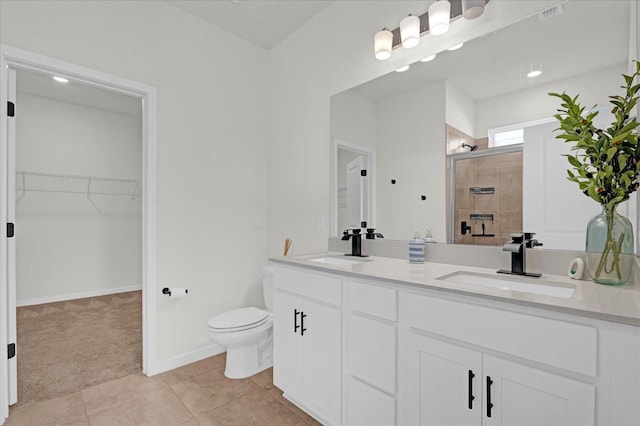 full bathroom with tile patterned flooring, visible vents, a tile shower, and a sink