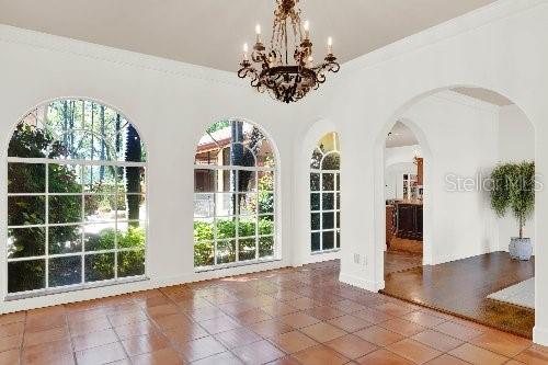 unfurnished dining area with tile patterned floors, plenty of natural light, and crown molding