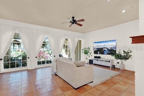 living room with crown molding and ceiling fan