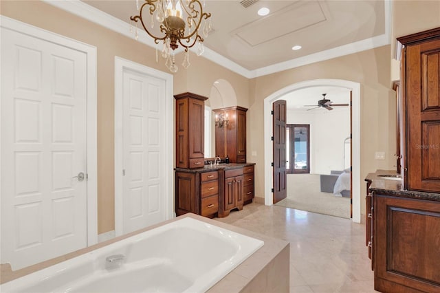 ensuite bathroom with ensuite bathroom, ceiling fan with notable chandelier, crown molding, a bath, and vanity