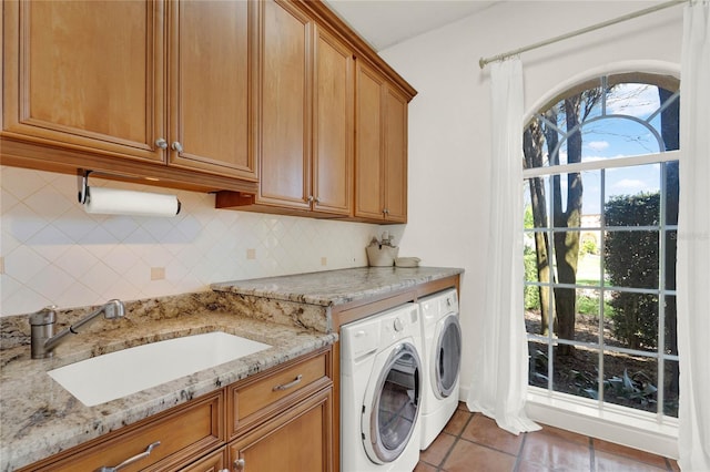 clothes washing area featuring cabinet space, washer and dryer, tile patterned floors, and a sink