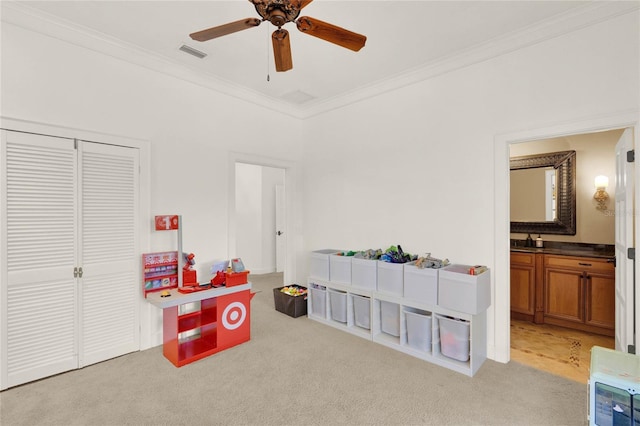 game room with visible vents, crown molding, light carpet, a ceiling fan, and a sink