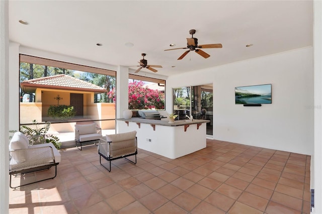 view of patio with an outdoor living space, area for grilling, and a ceiling fan