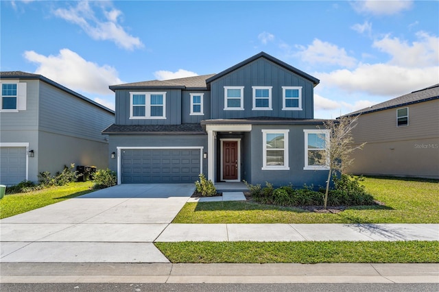 view of front of house featuring board and batten siding, a front yard, driveway, and a garage