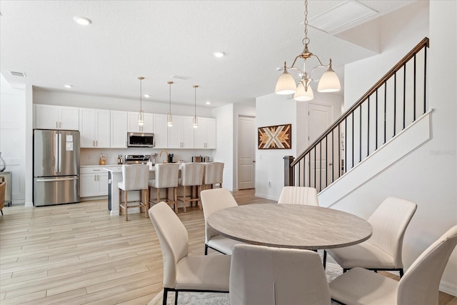 dining room with light wood-type flooring, visible vents, recessed lighting, and stairway