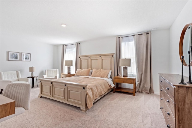 bedroom with multiple windows and light colored carpet