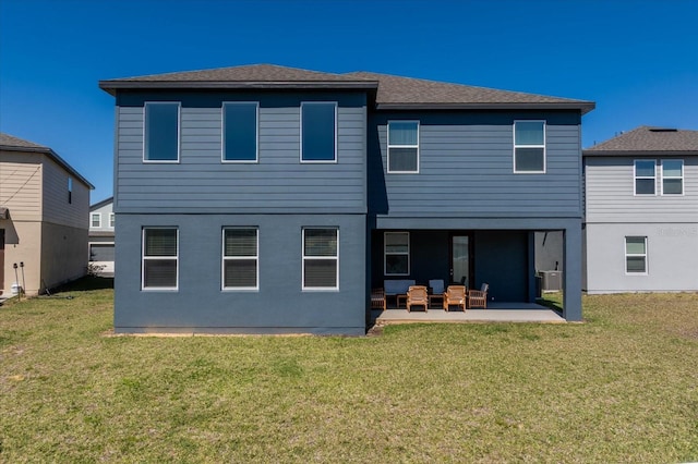 rear view of house with a yard, stucco siding, and a patio area