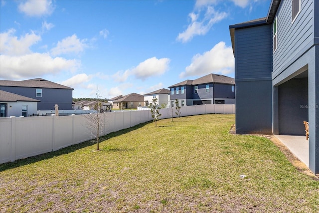 view of yard featuring a fenced backyard and a residential view