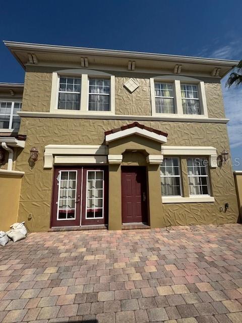 view of front facade with french doors and stucco siding