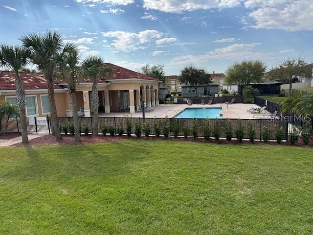 community pool featuring fence, a lawn, and a patio