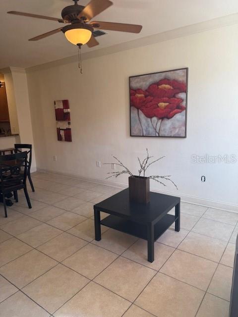 living room featuring light tile patterned floors, ceiling fan, and baseboards