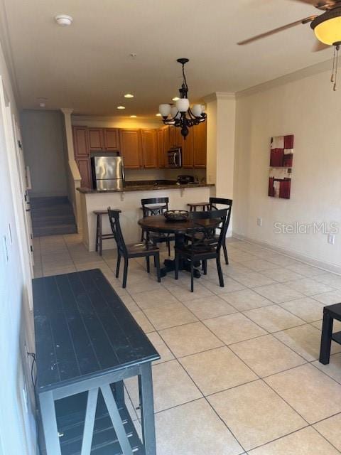 dining room with light tile patterned floors, ceiling fan with notable chandelier, and recessed lighting