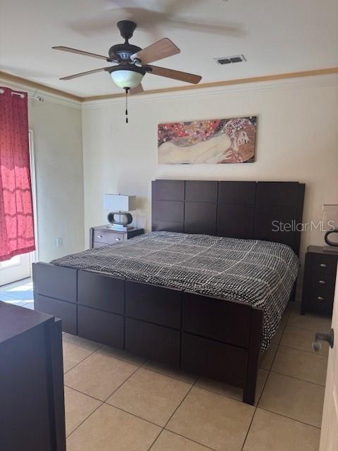 bedroom with light tile patterned floors, visible vents, ornamental molding, and a ceiling fan