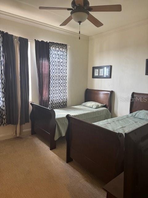 bedroom with carpet floors, crown molding, and a ceiling fan