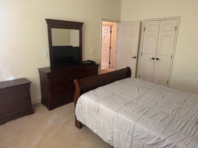 bedroom featuring a closet and light colored carpet