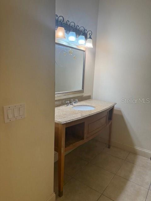 bathroom featuring tile patterned flooring, vanity, and baseboards