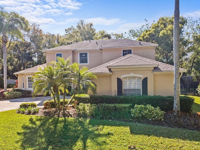 mediterranean / spanish-style house with stucco siding and a front lawn